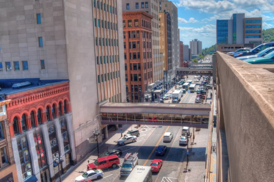 A busy street in Duluth, full of cars and buses.